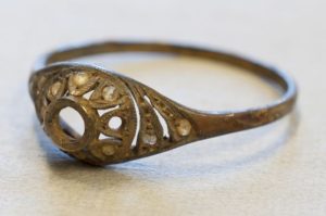 In this photo made available by the Auschwitz Museum in Oswiecim, Poland on Friday, 20 May 2016, a Polish-made golden ring is displayed . A spokesman for the Auschwitz Museum says a Polish-made golden ring and chain have been found hidden under the false base of an enameled mug that must have belonged to a victim of the Nazis' death camp. (www.auschwitz.org via AP)